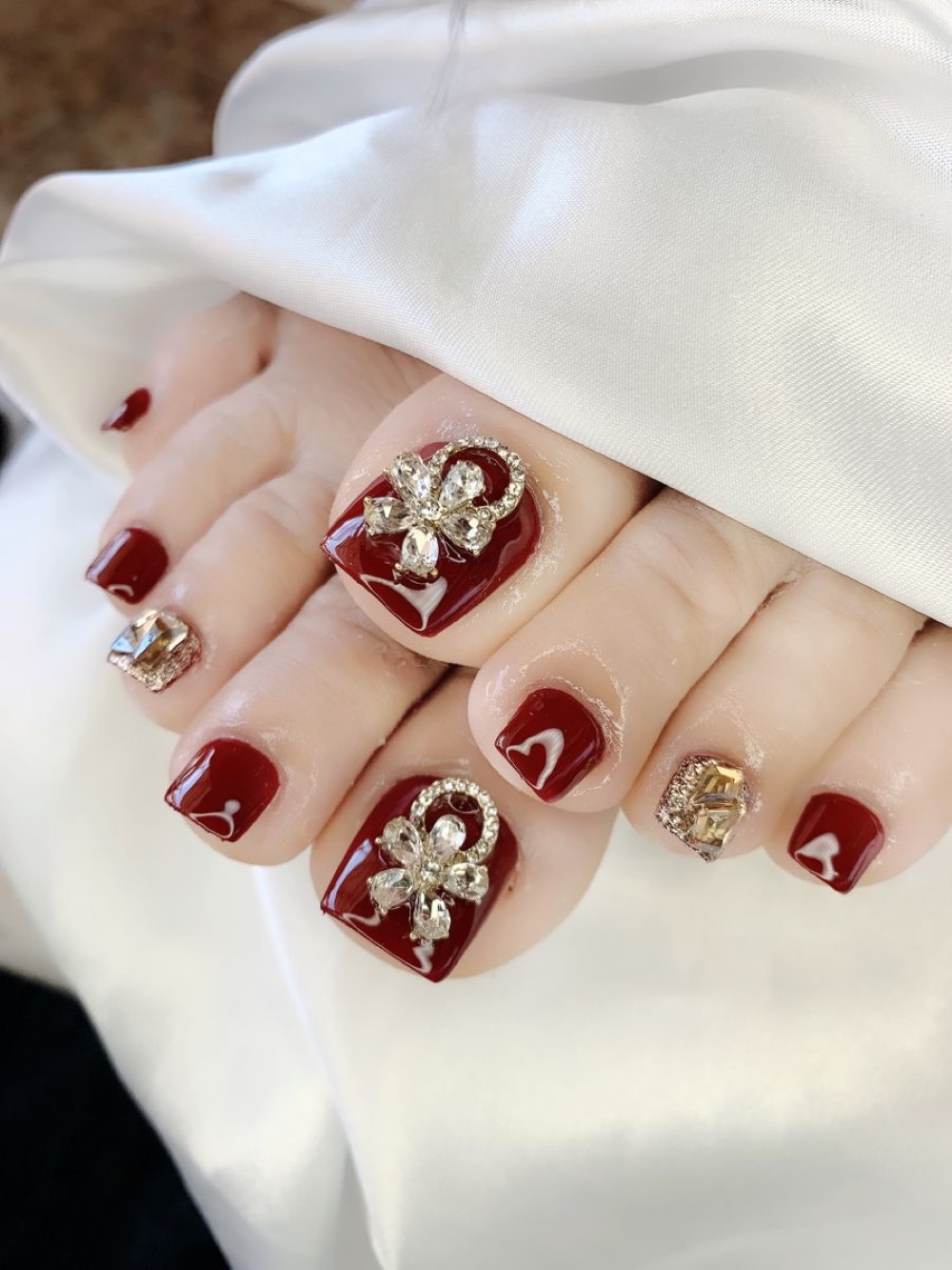 Nail chân màu đỏ đậm đính đá toát lên vẻ đẹp quý phái 