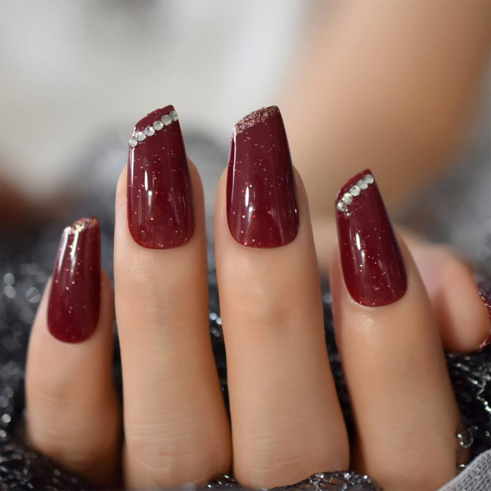 Đá quý được đính ở trên đầu móng tay màu đỏ đẹp