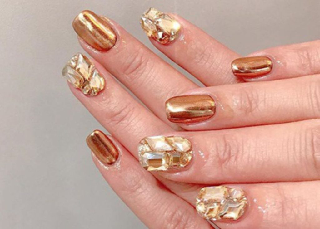 Diseño de uñas dorado elegante y noble.