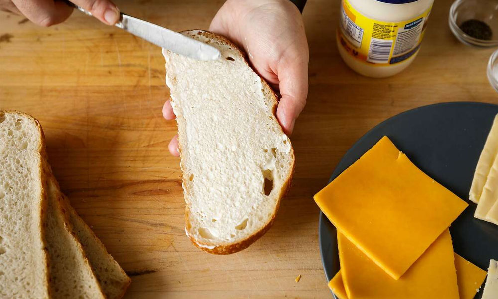 Phết phô mai lên bánh mì để tăng thêm độ ngậy của món ăn
