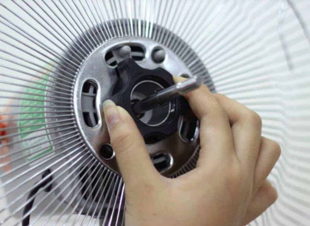 Tháo núm giữ để gỡ lồng quạt còn lại