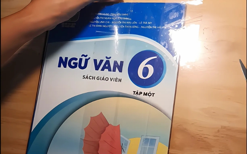 Bạn dán các dải băng keo theo chiều ngang của bìa sách