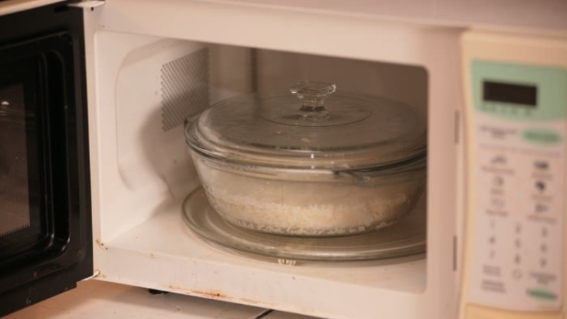 Thêm nước, che ẩm và hâm ngắn giúp cơm nguội ngày Tết nóng mềm, không khô