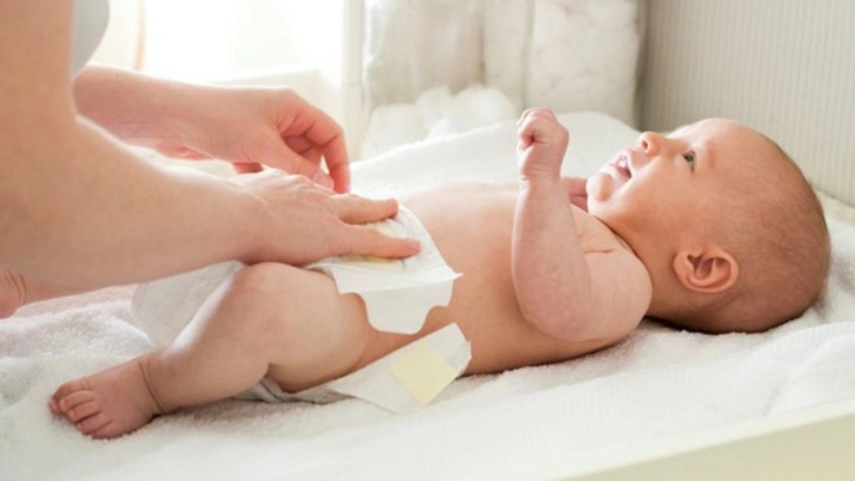 Thay tã ngay khi bé đại tiện để tránh phân và nước tiểu tạo amoniac gây tổn thương da